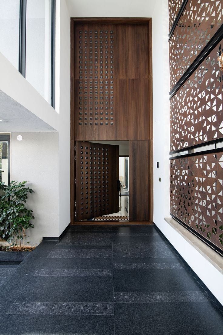 Tall Modern Entryway with Geometric Wood Door and Patterned Screens
