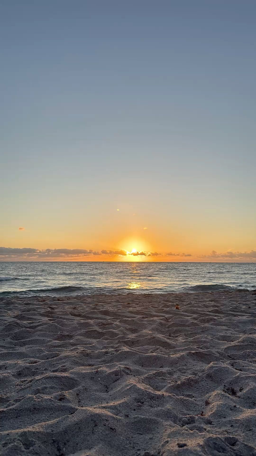 Tranquil Beach Sunrise with Gentle Waves and Sandy Shore