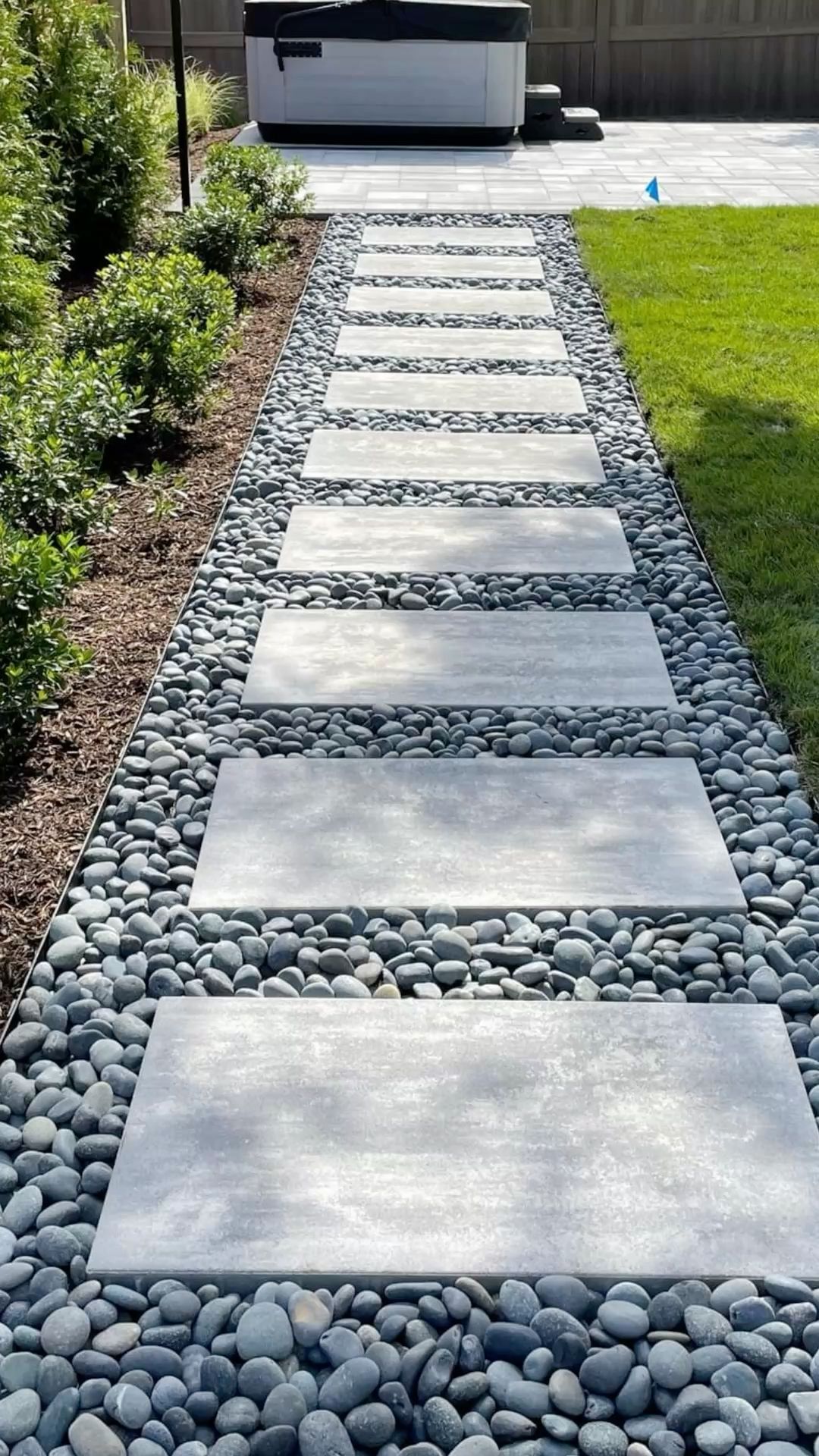 Modern Stepping Stone Walkway with River Rock Border in Backyard